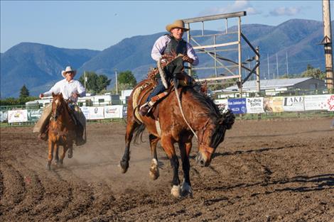 A rodeo competitor completes a successful ride in the saddle bronc event.