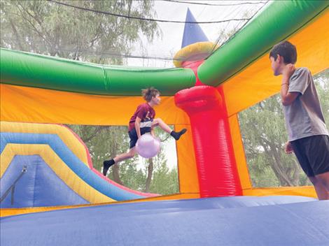 Remington Smith practices his basketball dunk skills in the bouncy house