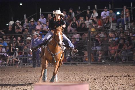 With her sights on the barrel ahead, a woman competes in Saturday’s barrel racing.