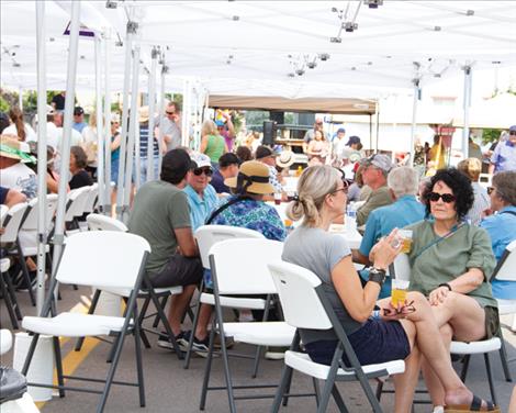 Rotary Brewfest attendees visit under a canopy of white tents.