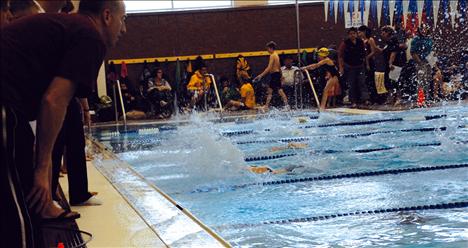 Coaches yell instructions to competing swimmers.