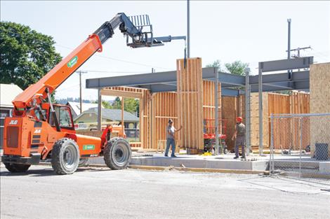 Construction workers place an interior wall panel in the new county annex building.