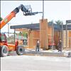 Construction workers place an interior wall panel in the new county annex building.