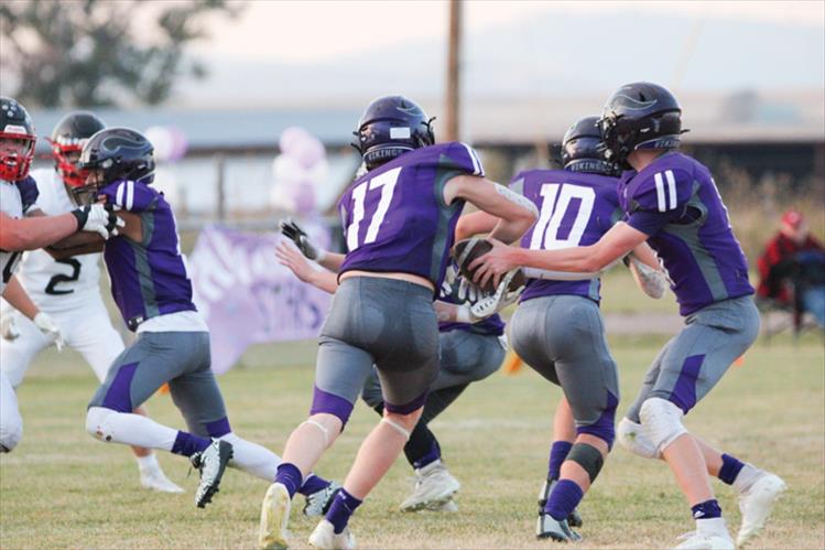 Karson Cox hands the football off to Brody Stinson during last Friday’s homecoming game. 