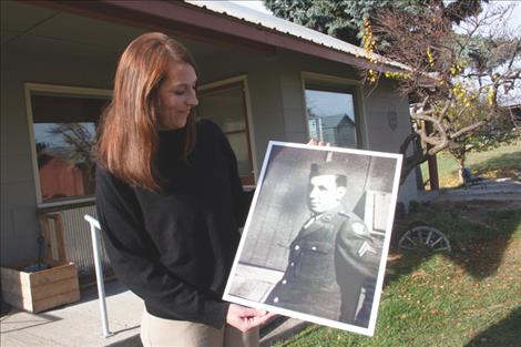 Emilie McGrath holds a photo of her grandfather in his WWII uniform.