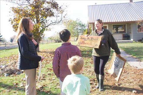 Kim Cochran, current owner of James Peace’s home in Valley View, shows his granddaughter Emilie McGrath a James Peace Ranch sign and an aerial photograph of the property taken in the 80s.