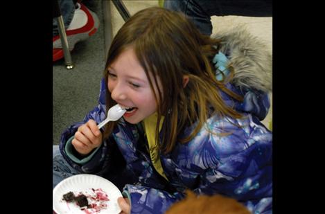 Fourth grader Mattison Holmes laughs with a classmate as she eats her beets.