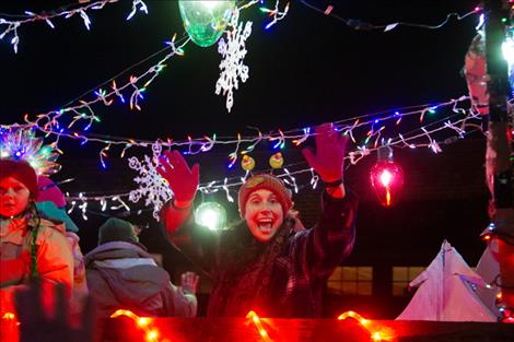 oleah Nicholas waves from atop the Head Over Heels float in the parade of lights