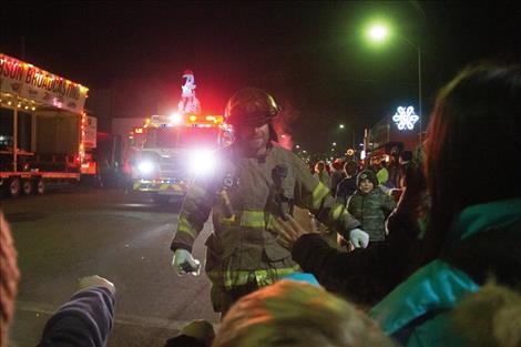 Polson firefighter Blake Holman hands out candy to kids during the parade.