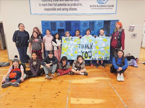 Boys and Girls Club members at the Ronan site hold up a sign they made to thank AT&T for their donation.