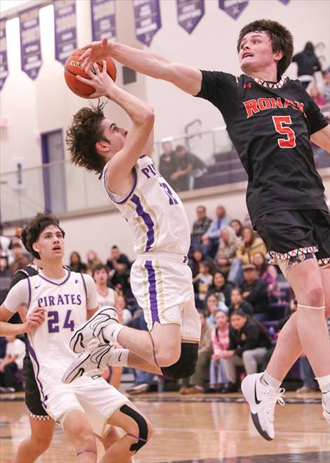 Ronan basketball player Lawrance Lozeau swats at a ball shot by Polson’s Jesse Vail. 