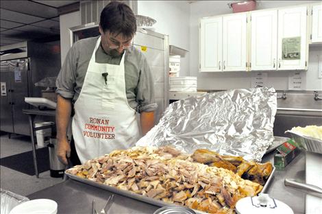 Volunteer Roland Godan shows off a portion of more than 36 turkeys prepared for the feast.