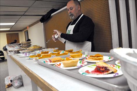 Volunteers from Ronan Dodge cut and serve donated pies.