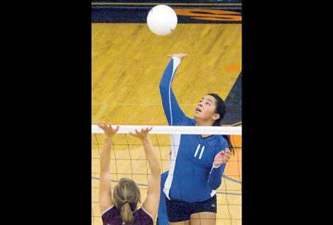 Emilie Charlo, a sophomore middle hitter, dominates the net against Troy during the divisional tournament.