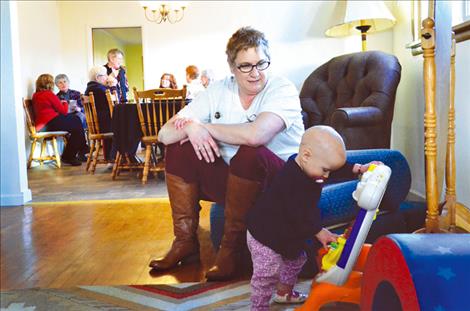 A visiting baby tries out the toys at The Nest with Lisa Skalsky, board president.