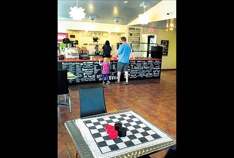 A checkers game awaits players on one of the many indoor tables.