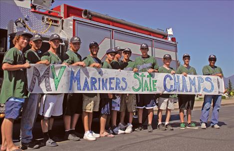 The Mission Valley Mariners show off their state champion  banner before they climb aboard a Polson fire truck for a victory lap around Polson. The ball players head to Idaho this week for the regional  tournament.